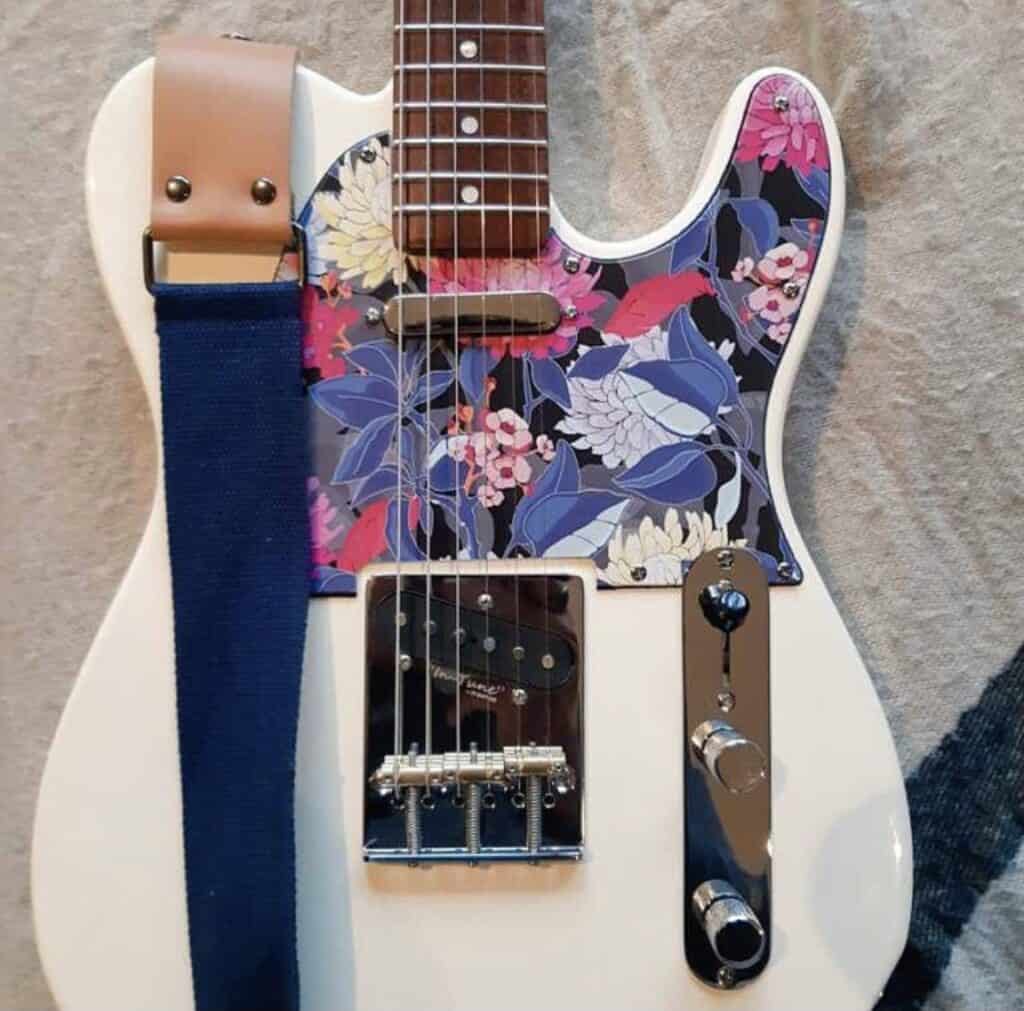 a tele style guitar with a custom pickguard