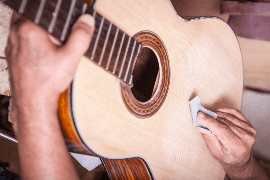 guitar luthier sanding a classical guitar