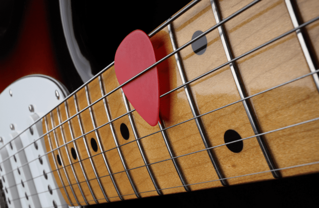electric guitar with glossy maple fretboard and a red pick