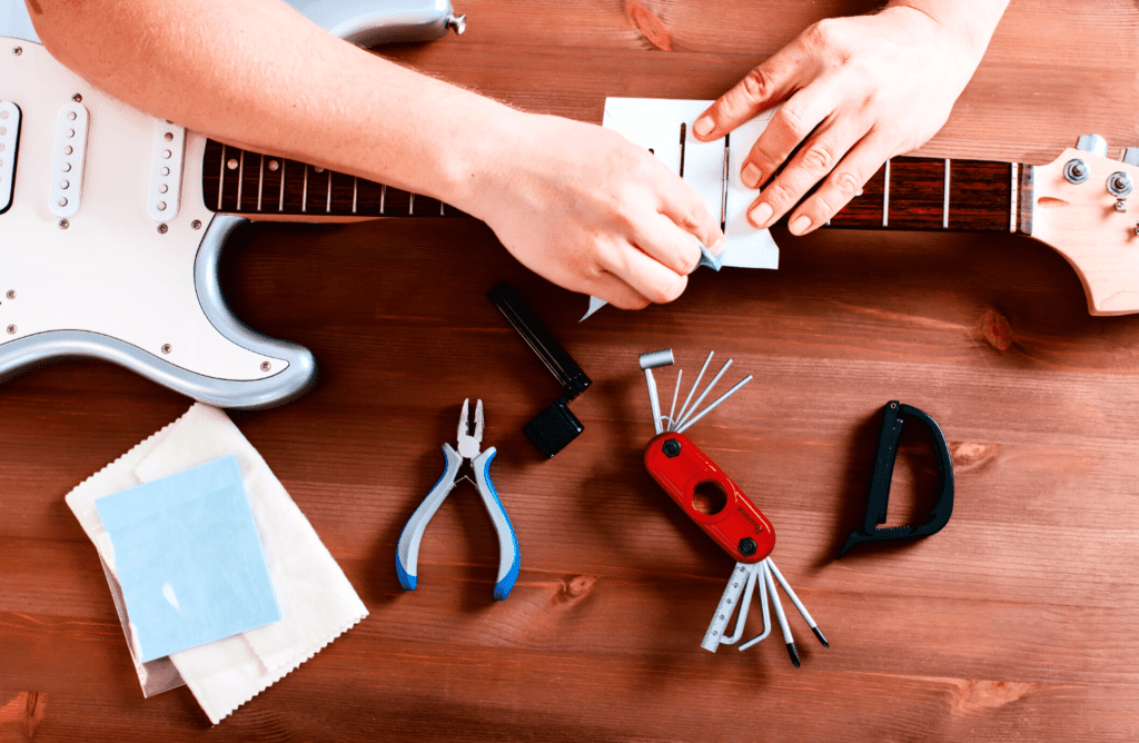 a light blue fender strat being set up on a table with guitar tools and and Ibanez MTZ11