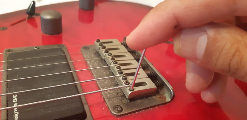 Adjusting the bridge height as a part of a guitar setup