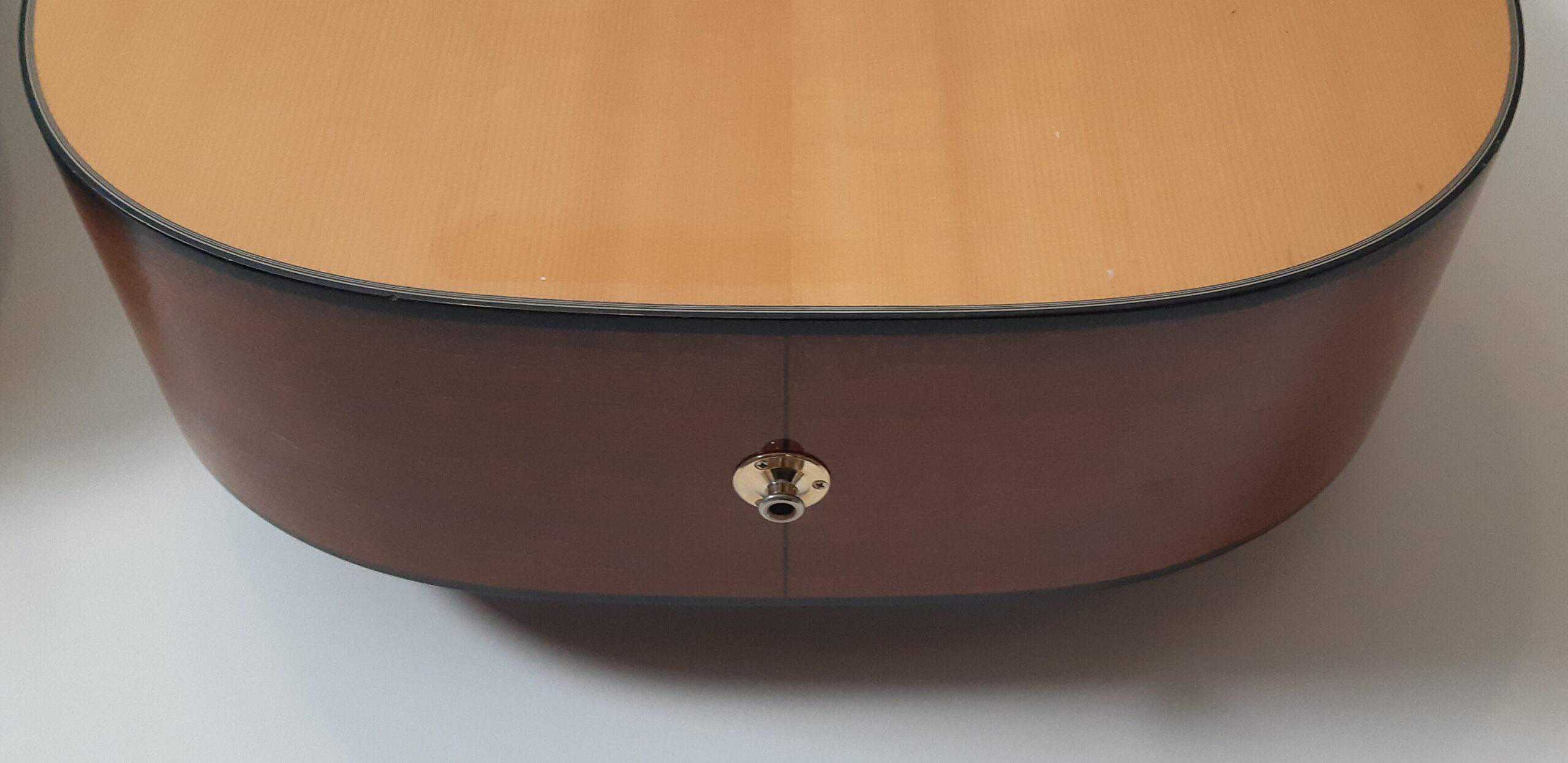 The strap button on an acoustic guitar