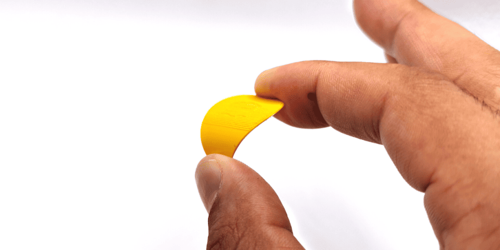 A yellow Herdim pick being bent