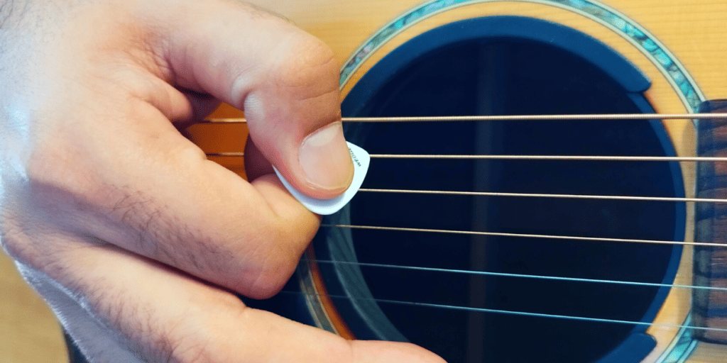 Holding the pick in 45 degree angle reduces pick noise because that way the pick resists the string with its entire width