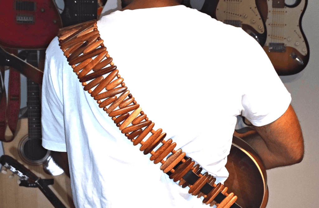 A guitar player wearing a Revo wooden guitar strap